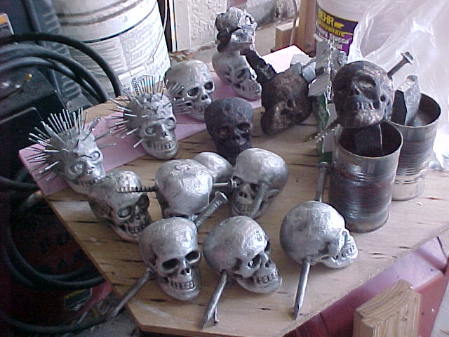 a table full of cast aluminum skulls ready to be mounted onto their wooden bases